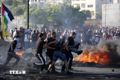 Chuyển người bị thương trong cuộc biểu tình phản đối các vụ không kích của Israel tại Huwwara, gần thành phố Nablus, Dải Gaza, ngày 18/5/2021. (Nguồn: THX/TTXVN) 