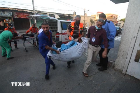 Chuyển thi thể nạn nhân thiệt mạng trong cuộc không kích của Israel xuống thành phố Rafah, Dải Gaza, ngày 16/5/2021. (Nguồn: THX/TTXVN) 