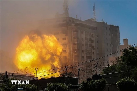 Khói lửa bốc lên từ Tòa tháp Jala, nơi đặt văn phòng một số hãng truyền thông quốc tế, khi tòa nhà này bị trúng không kích của Israel tại Dải Gaza, ngày 15/5/2021. (Nguồn: AFP/TTXVN) 