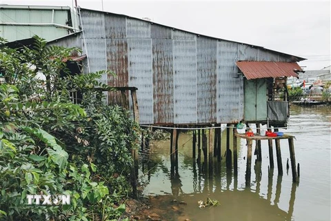 Một căn nhà trên tuyến sông Bò Ót, quận Thốt Nốt bị sạt lở đe doạ. (Ảnh: Thanh Liêm/TTXVN) 