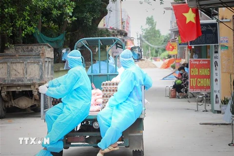 Tổ xung kích Đoàn thanh niên huyện Việt Yên hàng ngày chở lương thực tới từng nhà ở thôn Trung Đồng, xã Vân Trung, nơi người dân không được ra khỏi nhà vì bị cách ly. (Ảnh: Danh Lam/TTXVN) 
