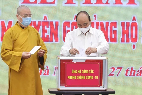 Chủ tịch nước Nguyễn Xuân Phúc quyên góp ủng hộ phòng, chống dịch COVID- 19. (Ảnh: Thống Nhất/TTXVN) 