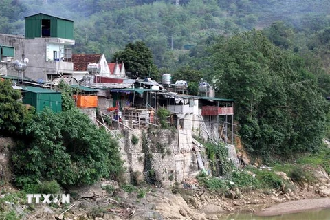 Những ngôi nhà dựng đứng bên bờ sông của một số hộ dân thị trấn Mường Xén, huyện Kỳ Sơn (Nghệ An) tiềm ẩn nguy cơ sạt lở bất cứ lức nào. (Ảnh: Văn Tý/TTXVN) 