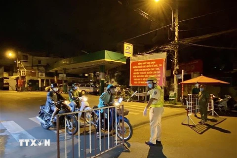 Lực lượng cảnh sát giao thông yêu cầu người dân dừng xe khai báo y tế trên đường Lê Quang Định (phường 1, quận Gò Vấp, Thành phố Hồ Chí Minh). (Ảnh: Hồng Giang/TTXVN) 
