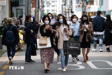 Người dân đeo khẩu trang phòng dịch COVID-19 khi đi trên đường phố tại Seoul, Hàn Quốc, ngày 18/4/2021. (Nguồn: Bloomberg/TTXVN) 