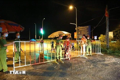 Lực lượng chức năng lập các chốt phong tỏa tại khu vực các ca bệnh sinh sống ở thị trấn Lộc Hà. (Nguồn: TTXVN phát) 