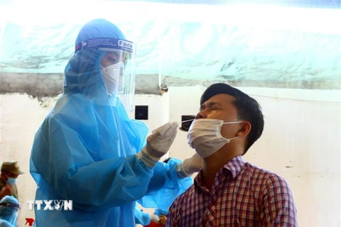 Cán bộ y tế lấy mẫu xét nghiệm cho người dân phường Hà Huy Tập, thành phố Vinh, tỉnh Nghệ An (sáng 14/6/2021). (Ảnh: Tá Chuyên/TTXVN)