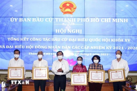 Bí thư Thành ủy Thành phố Hồ Chí Minh Nguyễn Văn Nên (thứ 3 từ trái sang) trao Bằng khen của Chủ tịch Ủy ban Nhân dân Thành phố cho các cá nhân có thành tích xuất sắc trong công tác chuẩn bị, tổ chức bầu cử. (Nguồn: TTXVN phát) 