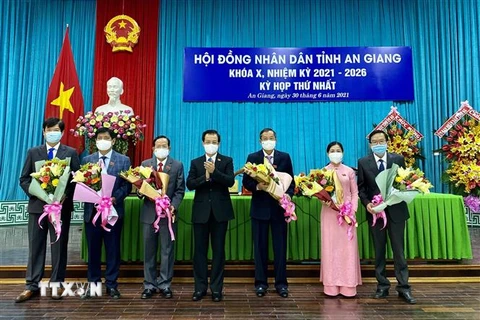 Ông Lê Hồng Quang (giữa), Ủy viên Ban chấp hành Trung ương Đảng, Bí thư Tỉnh ủy An Giang, tặng hoa cho các đồng chí Thường trực Hội đồng Nhân dân tỉnh khóa X, nhiệm kỳ 2021-2026. (Ảnh: Thanh Sang/TTXVN) 