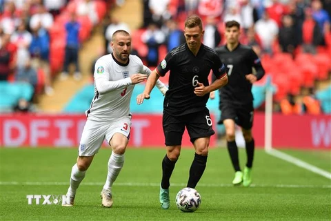 Tiền vệ Đức Joshua Kimmich (phải) nỗ lực đi bóng trước hậu vệ Anh Luke Shaw trong trận đấu ở vòng 16 đội, Vòng chung kết EURO 2020, trên sân vận động Wembley ở London, Anh, ngày 29/6/2021. (Nguồn: AFP/TTXVN) 