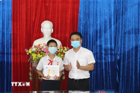 Đại diện lãnh đạo Tỉnh đoàn Gia Lai đã trao tặng huy hiệu Tuổi trẻ dũng cảm cho em Trần Nguyễn Anh Duy, Trường Trung học cơ sở Nguyễn Văn Cừ, xã Biển Hồ, thành phố Pleiku. (Ảnh: Hồng Điệp/TTXVN)
