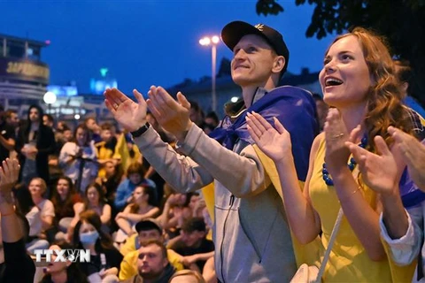 Người hâm mộ Ukraine ở quê nhà Kiev cổ vũ đội tuyển trong trận gặp Thụy Điển trong khuôn khổ trận đấu vòng 16 đội, chung kết EURO 2020 trên sân Glasgow, Scotland, ngày 29/6/2021. (Nguồn: AFP/TTXVN) 