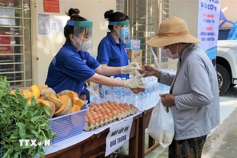 Đoàn viên thanh niên huyện Nhà Bè hỗ trợ người dân mua sắm thực phẩm tại siêu thị 2.000 đồng ở xã Hiệp Phước. (Ảnh: Hồng Giang/TTXVN) 