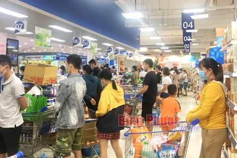 Người dân đi siêu thị gom hàng tại Siêu thị Co.op mart Đồng Xoài tối 8/7. (Nguồn: Báo Bình Phước) 