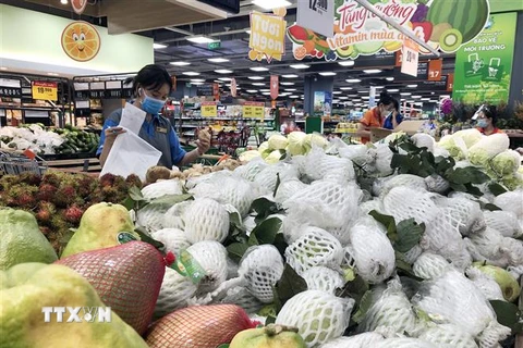Nhân viên siêu thị tại Thành phố Hồ Chí Minh lựa chọn thực phẩm cho đơn hàng mua sắm online. (Ảnh: Mỹ Phương/TTXVN) 