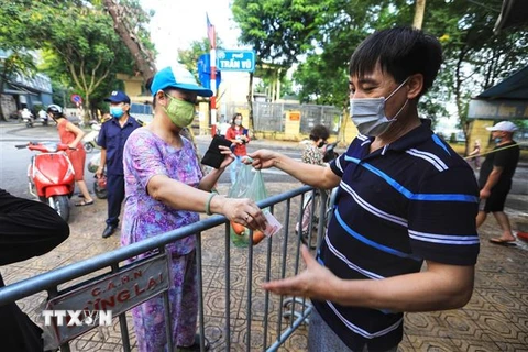 Tại chợ Châu Long (quận Ba Đình), việc lắp rào chắn giữa người mua và người bán đảm bảo giãn khoảng cách cần thiết. (Ảnh: Thành Đạt/TTXVN) 