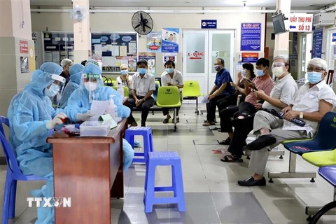 Các y, bác sỹ Trung tâm Y tế quận 11, Thành phố Hồ Chí Minh tiêm vaccine Moderna phòng COVID-19 trong đợt 5 cho khoảng 3.120 người trên 65 tuổi, người mắc bệnh mãn tính. (Ảnh: Hồng Giang/TTXVN) 