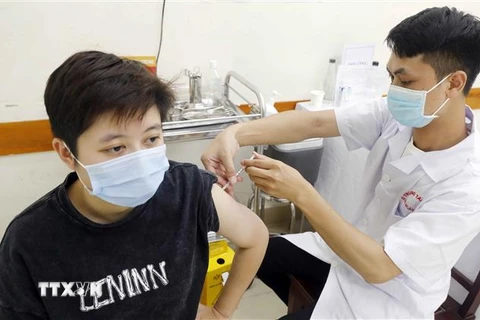 Tiêm vaccine phòng COVID-19 cho người dân tại điểm tiêm Trường THCS Trưng Vương, quận Hoàn Kiếm, ngày 3/8/2021. (Ảnh: Trần Việt/TTXVN) 