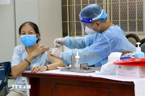 Các y bác sỹ quận 3, Thành phố Hồ Chí Minh tiêm vaccine phòng COVID-19 cho người trên 65 tuổi tại điểm tiêm trường tiểu học Trần Quốc Thảo trong sáng 3/8. (Ảnh: Thanh Vũ/TTXVN) 