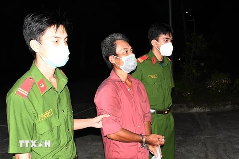 Lực lượng công an khống chế, áp giải Nguyễn Thanh Bình về trụ sở. (Ảnh: Phúc Sơn/TTXVN) 