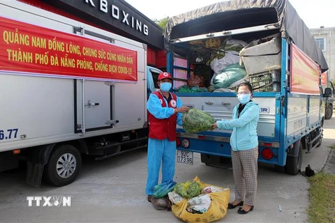 Đại diện huyện Đại Lộc (trái) trao tượng trưng số hàng hóa hỗ trợ người dân vùng bị phong tỏa, cách ly quận Sơn Trà. (Ảnh: Trần Lê Lâm/TTXVN) 