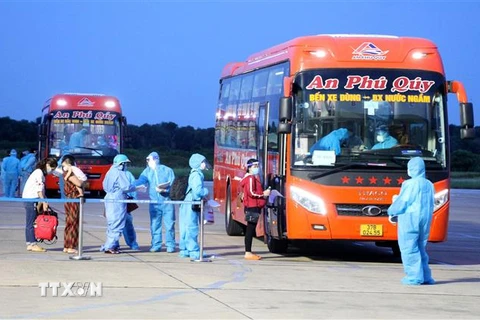 Người dân Nghệ An sau khu xuống sân bay được khẩn trương đưa về nơi cách ly. (Ảnh: Văn Tý/TTXVN) 