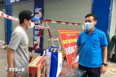 Công đoàn Thành đoàn Thành phố Hồ Chí Minh trao quà hỗ trợ cho người lao động trong khu phong tỏa, cách ly. (Ảnh: Thanh Vũ/TTXVN) 