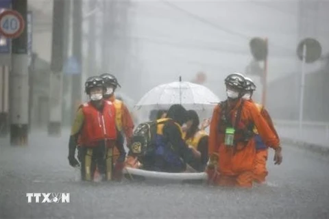 Nhân viên cứu hộ sơ tán người dân khỏi khu vực ngập lụt do mưa lớn ở thành phố Kurume, tỉnh Fukuoka, miền Tây Nam Nhật Bản, ngày 14/8/2021. (Ảnh: Kyodo/TTXVN) 