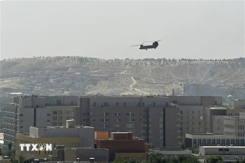 Máy bay quân sự Mỹ bay trên tòa nhà Đại sứ quán Mỹ ở Kabul, Afghanistan, khi hoạt động sơ tán được tiến hành, ngày 15/8/2021. (Ảnh: AFP/TTXVN) 