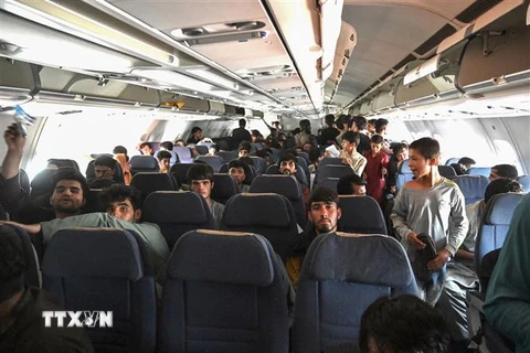 Người dân Afghanistan trên máy bay chuẩn bị rời sân bay Kabul ngày 16/8/2021. (Ảnh: AFP/TTXVN) 