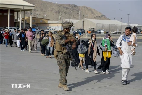 Dòng người xếp hàng lên máy bay sơ tán tại sân bay Hamid Karzai ở Kabul, Afghanistan ngày 18/8/2021. (Ảnh: AFP/TTXVN) 