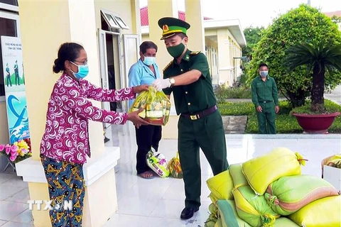 Đại tá Nguyễn Trìu Mến, Chính ủy Bội đội Biên phòng Sóc Trăng tặng quà cho người nghèo. (Ảnh: TTXVN/phát) 