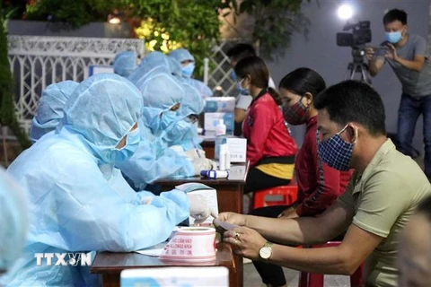 Lực lượng chức năng tổ chức lấy mẫu xét nghiệm sàng lọc SARS-CoV-2 cho tiểu thương chợ đêm Pleiku. (Ảnh: Quang Thái/TTXVN) 