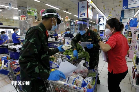 Nhiều chiến sỹ nhờ trợ giúp thông tin, hàng hóa từ các nhân viên siêu thị để đi chợ giúp dân đúng và đầy đủ theo nhu cầu. (Ảnh: Thanh Vũ/TTXVN) 