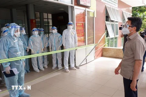 Phó Thủ tướng Chính phủ Vũ Đức Đam thăm hỏi cán bộ y tế Bệnh viện Đa khoa khu vực Hậu Nghĩa, huyện Đức Hòa, Long An. (Ảnh: TTXVN phát) 