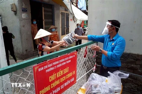 Liên đoàn Lao động quận Bình Thạnh trao quà cho người lao động trong khu vực phong tỏa. (Ảnh: Thanh Vũ/TTXVN) 