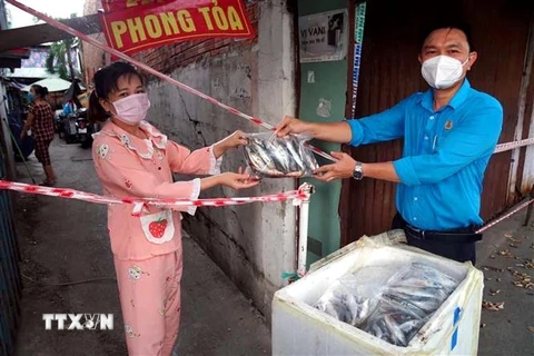 Liên đoàn Lao động quận 8 trao tặng cá của ngư dân tỉnh Quảng Bình cho người lao động khu vực phong tỏa. (Ảnh: Thanh Vũ/TTXVN) 