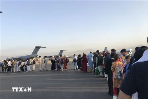 Người dân xếp hàng lên máy bay quân sự của Đức ở sân bay quốc tế Kabul (Afghanistan), để rời khỏi quốc gia Tây Nam Á, ngày 25/8/2021. (Ảnh: THX/TTXVN) 