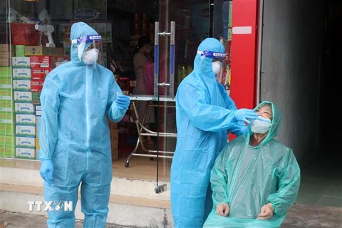 Nhân viên y tế lấy mẫu xét nghiệm virus SARS-CoV-2 trên địa bàn phường Vĩnh Bảo, thành phố Rạch Giá (Kiên Giang). (Ảnh: Lê Huy Hải/TTXVN) 