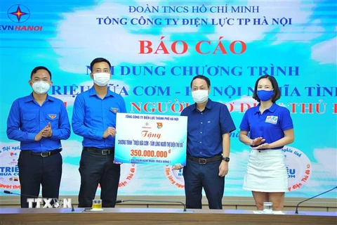 Ông Nguyễn Đức Tiến, Phó Bí thư Thường trực Thành đoàn, Chủ tịch Hội Liên hiệp Thanh niên Việt Nam thành phố Hà Nội tiếp nhận bảng tượng trưng tặng 14.000 suất ăn từ ông Nguyễn Anh Dũng, Phó Tổng Giám đốc Công ty Điện lực Hà Nội. (Ảnh: Minh Đức/TTXVN) 