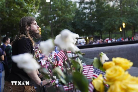Thân nhân của các nạn nhân vụ khủng bố 11/9 đặt hoa tại lễ tưởng niệm nhân kỷ niệm 20 năm vụ khủng bố 11/9 ở New York, Mỹ, ngày 11/9/2021. (Ảnh: THX/TTXVN) 