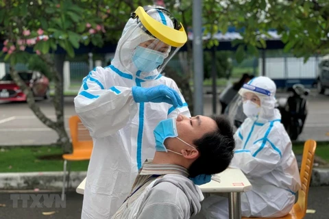 Các y bác sỹ Trung tâm kiểm soát bệnh tật Thành phố Hồ Chí Minh và quận 7 thực hiện xét nghiệm sàng lọc COVID-19. (Ảnh: Thanh Vũ/TTXVN) 