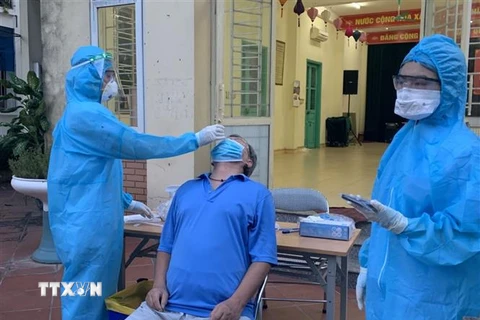 Lực lượng y tế lấy mẫu xét nghiệm những người liên quan đến các ca dương tính ở phường Việt Hưng (quận Long Biên, Hà Nội). (Ảnh: Văn Cảnh/TTXVN)