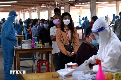 Người lao động tại Công ty Pousung Việt Nam làm các thủ tục trước khi vào nhà máy làm việc. (Ảnh: Công Phong/TTXVN) 
