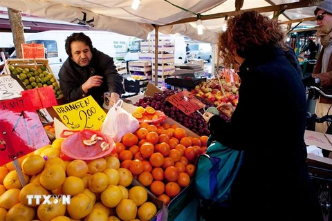 Người dân mua thực phẩm tại một khu chợ ở thủ đô Berlin, Đức. (Ảnh: AFP/TTXVN) 