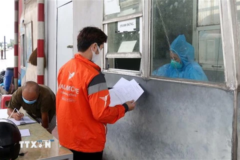 Người dân làm thủ tục khai báo y tế tại chốt kiểm soát liên ngành phòng, chống dịch COVID-19 Dốc Xây, thị xã Bỉm Sơn, Thanh Hóa. (Ảnh: Nguyễn Nam/TTXVN) 