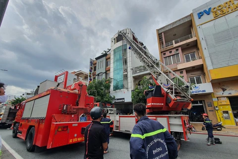 Lực lượng phòng cháy chữa cháy điều xe thang đến hiện trường dập lửa. (Nguồn: tuoitre.vn) 