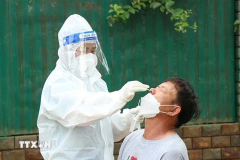 Nhân viên y tế lấy mẫu xét nghiệm cho người dân thành phố Buôn Ma Thuột. (Ảnh: Tuấn Anh/TTXVN) 
