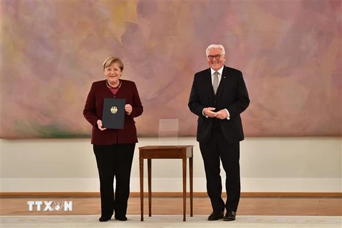 Tổng thống Đức Frank-Walter Steinmeier (phải) sau khi trao quyết định kết thúc nhiệm kỳ công tác cho Thủ tướng Angela Merkel (trái) tại Cung điện Bellevue ở Berlin ngày 26/10/2021. (Ảnh: AFP/TTXVN) 