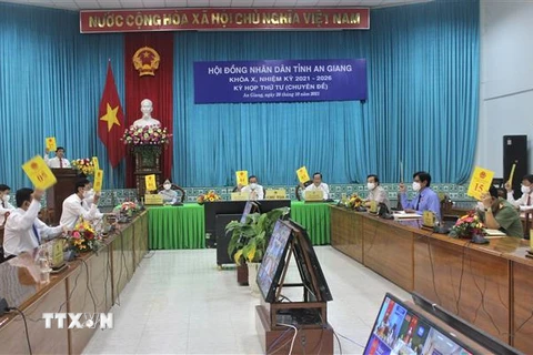 Các đại biểu tham dự kỳ họp tại điểm cầu Văn phòng Ủy ban Nhân dân tỉnh biểu quyết thông qua các nghị quyết. (Ảnh: Thanh Sang/TTXVN) 